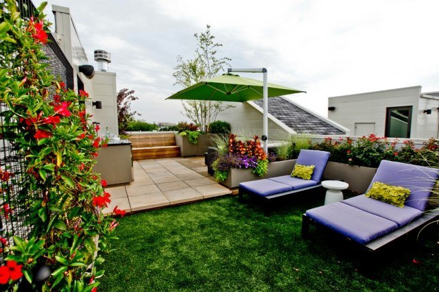 Cadeiras reclináveis ​​grama artificial cerca viva com guarda-sol e área de estar