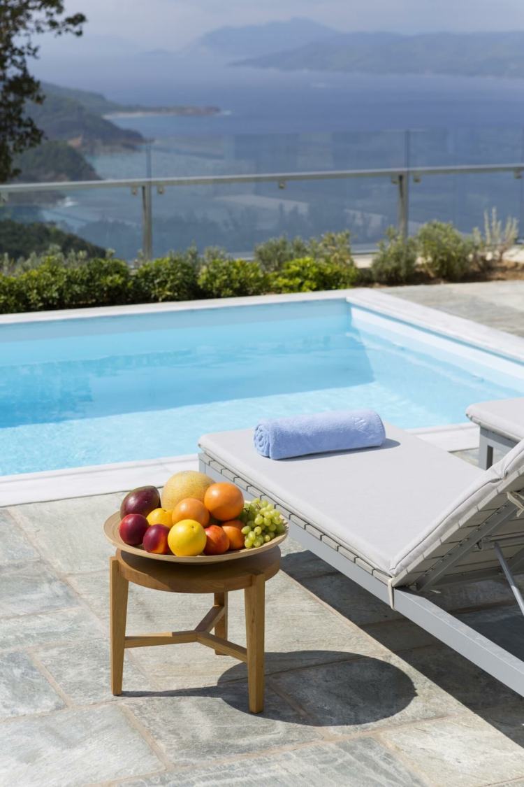 mediterrâneo-parede-pedra-relaxar-piscina-chaise longue-cinza-mesa lateral-frutas