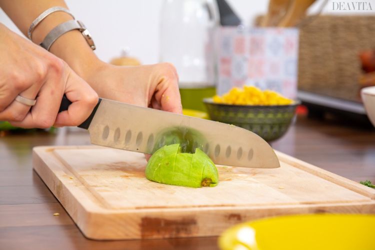 Prepare a receita da salada mexicana simplesmente corte os pedaços de abacate na tábua da cozinha
