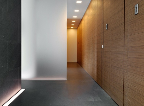 Painéis de madeira no corredor minimalista com iluminação LED para piso