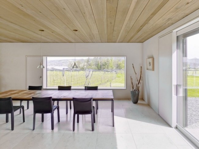 sala de jantar com vista para casa de madeira minimalista no lago de zurique