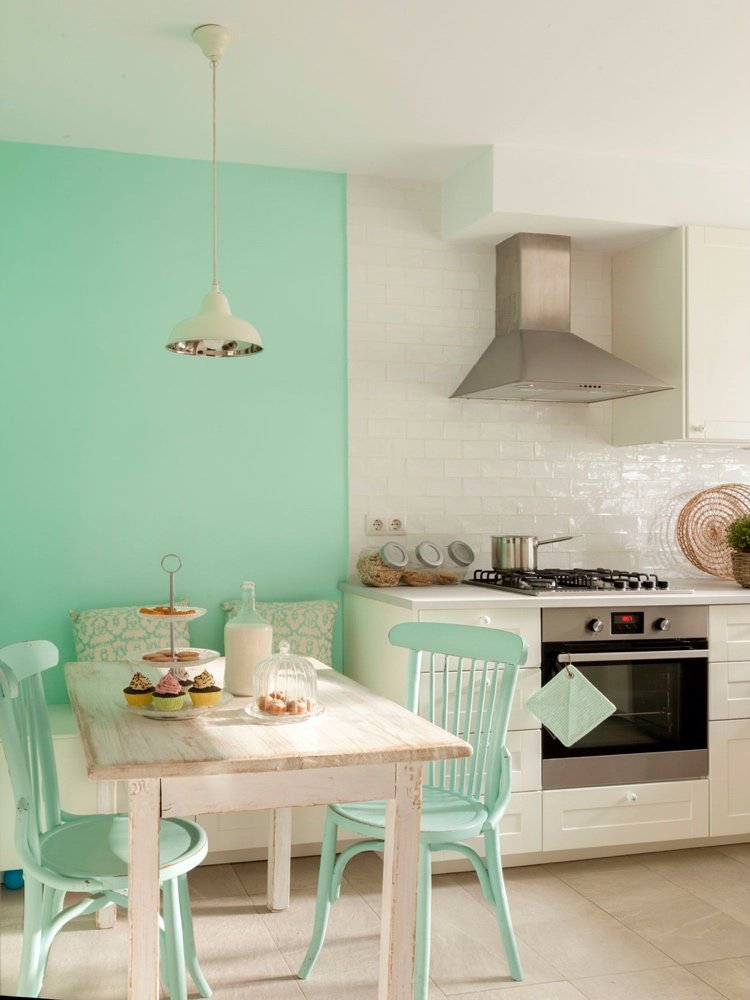Cor pastel de menta em uma parede de destaque em uma cozinha country
