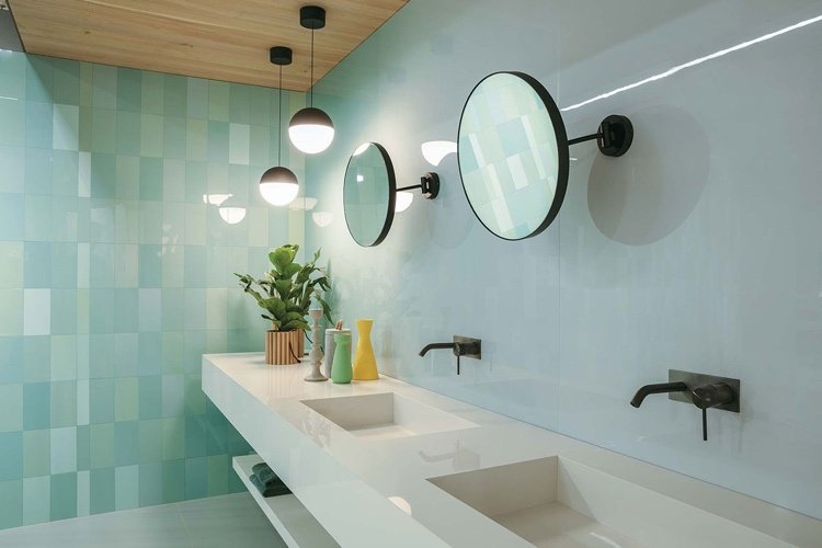 Azulejos de menta combinados com acessórios pretos no banheiro moderno