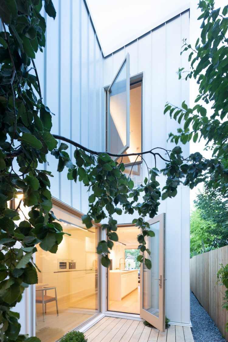 fachada estreita da casa com pátio revestido de metal branco