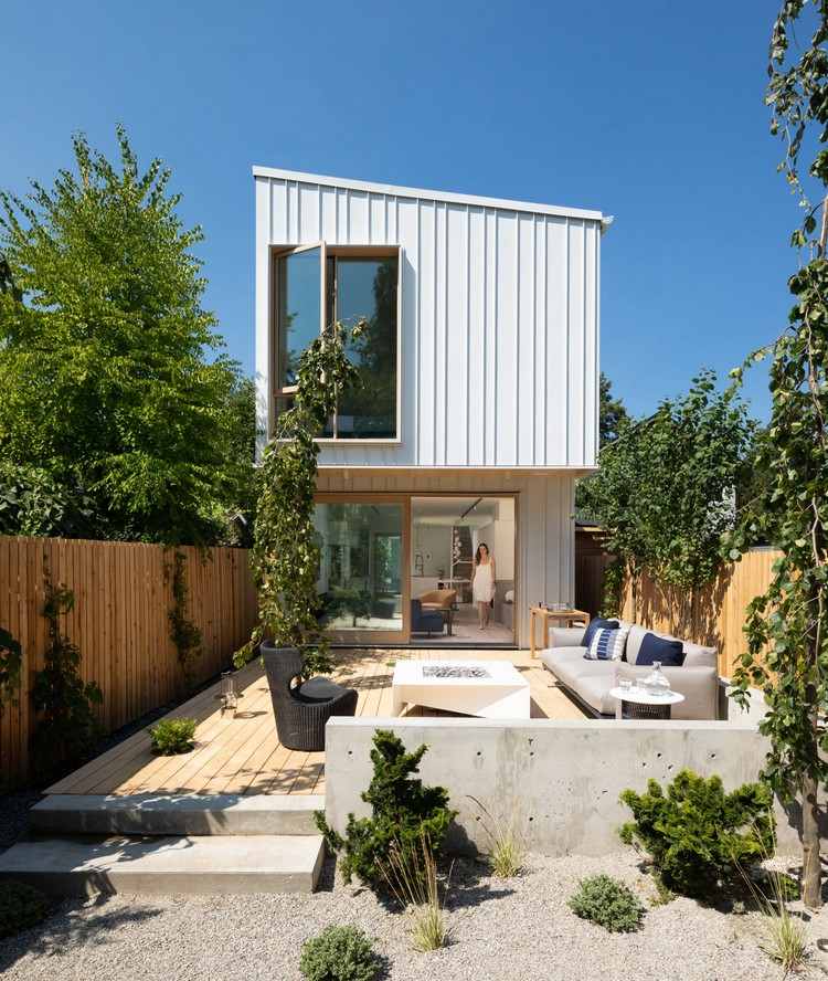 casa estreita de dois andares com costura com revestimento de metal branco quintal