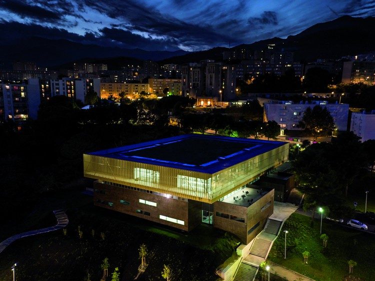 vista do pássaro à noite vista do telhado iluminado de azul da cidade