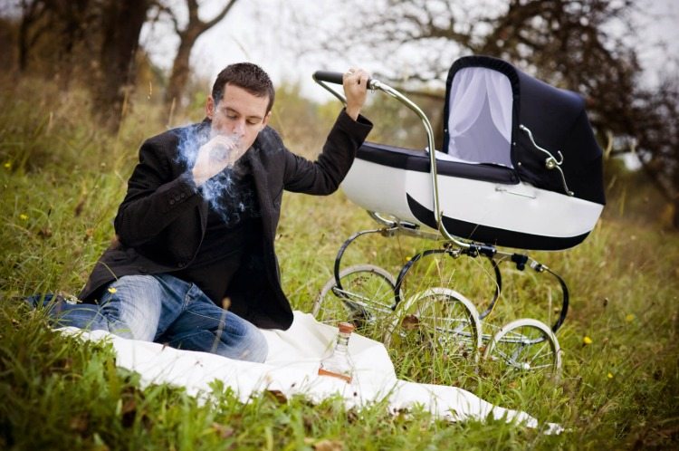 pai fumando charuto no meio da natureza com carrinho de bebê estilo retro