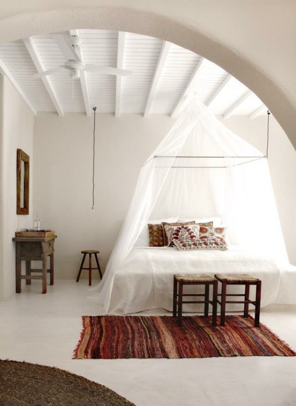 Painéis do teto revestindo o quarto branco com cama de dossel