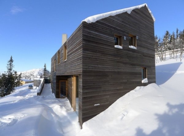 Cabana de férias moderna na Noruega construída em uma fachada de madeira inclinada