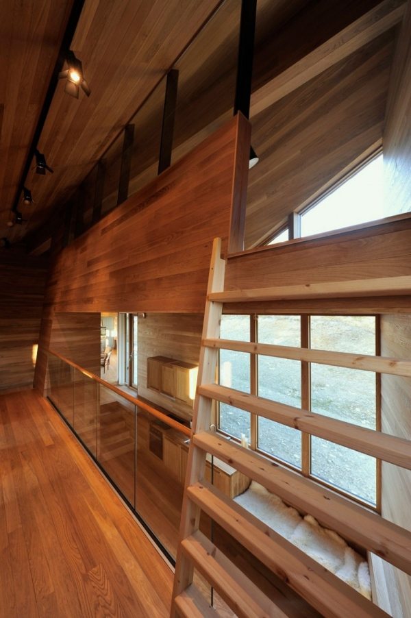 Cabine com telhado inclinado e painéis de madeira com vista para o guarda-corpo de vidro