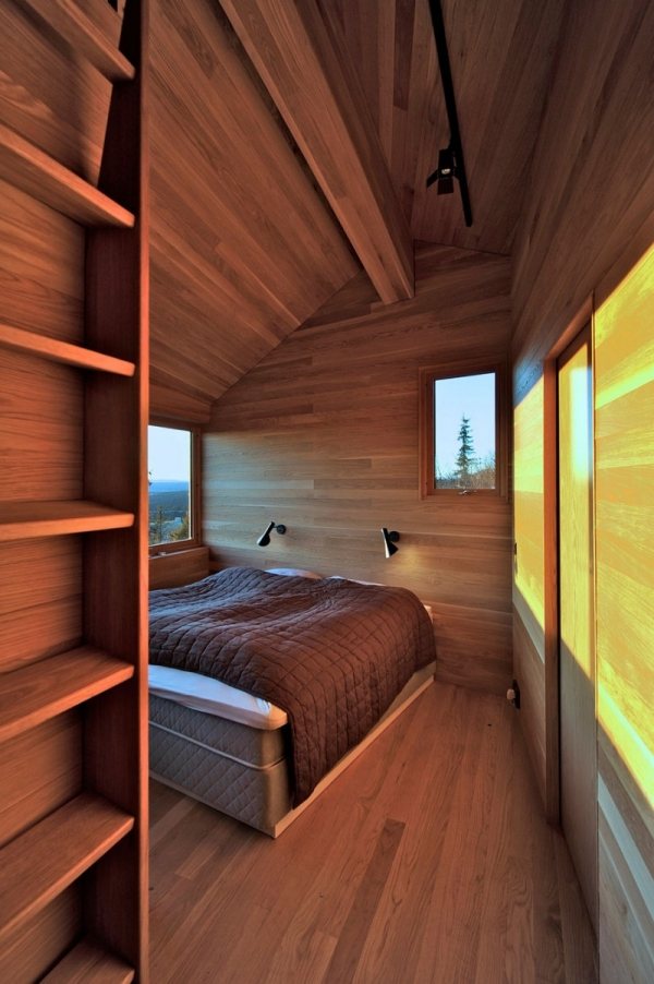 Quarto em cabana na Noruega com telhado de madeira inclinado