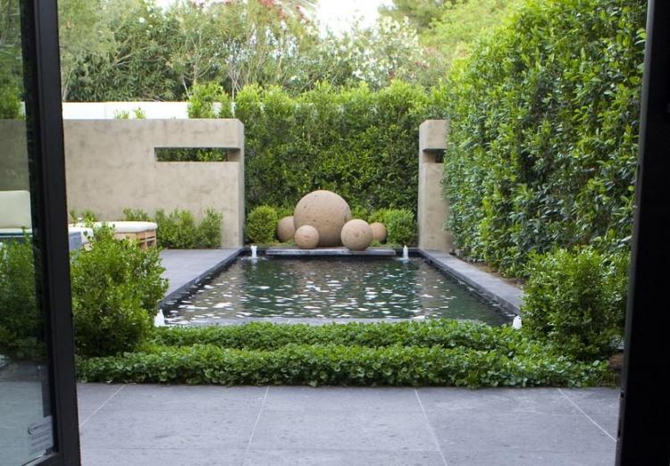 arte-jardim-moderno-lagoa-privacidade-cerca-viva-decoração com bolas de pedra