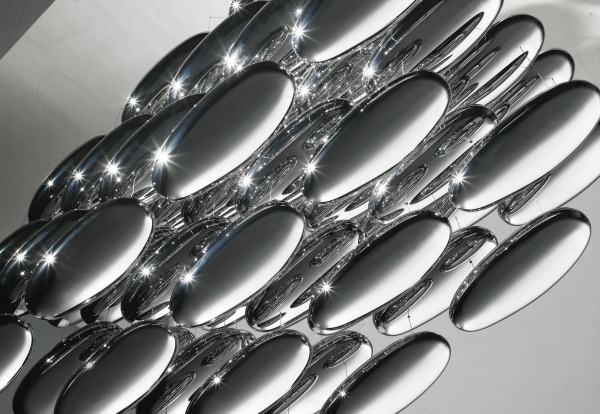 A luminária com elementos de espelho cria um efeito de teto de metal