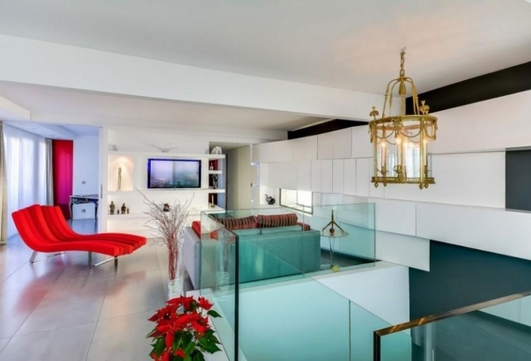 Design interior moderno - candelabro-ouro-antigo-espreguiçadeira-otomano-vermelho-sofá-revestimento de parede-branco