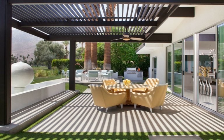 moderno-pérgula-concreto-pavimentação-pedras-cadeiras-amarelas-jardim com assentos
