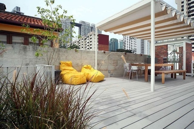 terraço na cobertura-pérgula-área de jantar-privacidade-tela-pufes amarelos