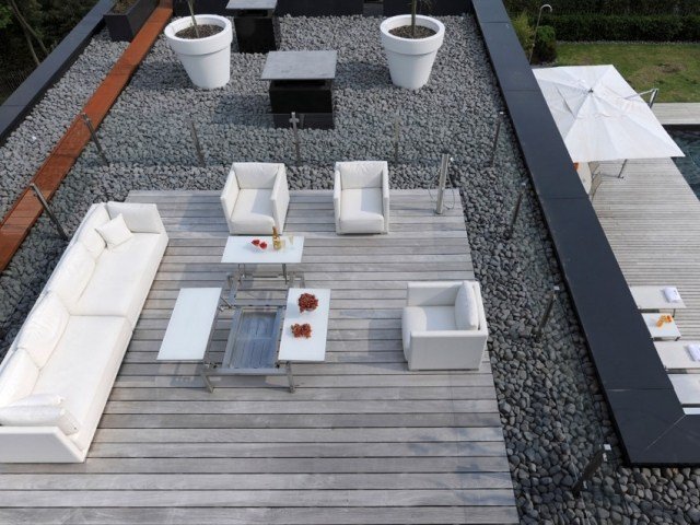terraço na cobertura-madeira-cinza-seixos-móveis brancos