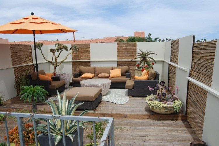 Terraço na cobertura-tela de privacidade-rattan-lounge-móveis-laranja-guarda-sol-almofadas