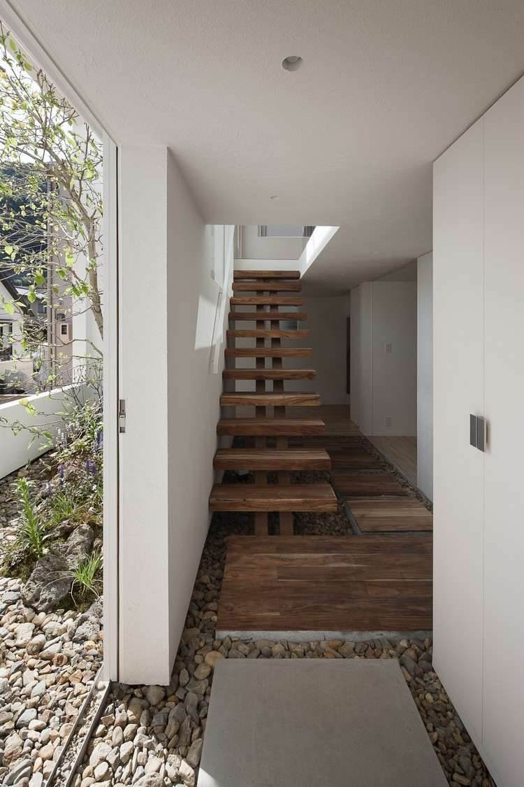 Escada de madeira maciça sem corrimão decoração de pedra na área externa