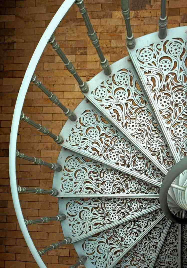 Escada em espiral com motivos decorativos de degraus em aço