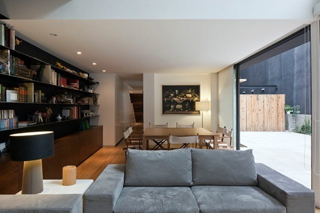 Living Ideas sofá de dois lugares cinza claro estante com almofada preta abajur de mesa pequeno