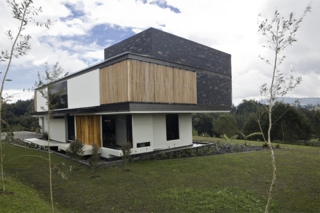 casa moderna folheado a pedra preta ripas de madeira