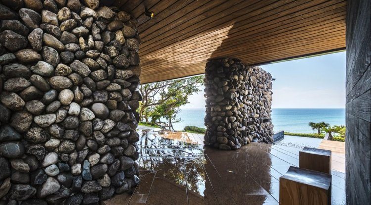 pedras naturais-pedregulhos-arquitetura moderna-terraço-luxo-teto de madeira-vista para o mar-jardim