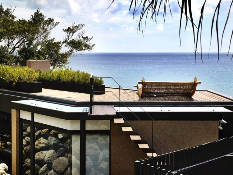 pedras naturais-pedregulhos-arquitetura moderna-terraço-terraço-vista para o mar-assoalho de madeira-espreguiçadeiras