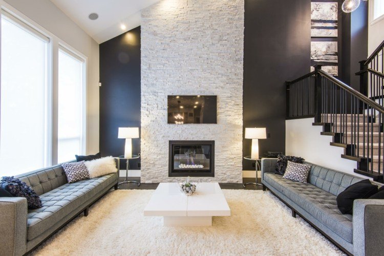 parede de pedra natural na sala de estar akzent chaminé branco elegante sofás cinza