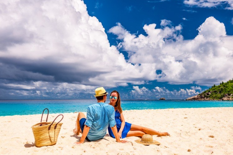 jovem casal em uma praia vazia durante a baixa temporada de 2020 em seychelles
