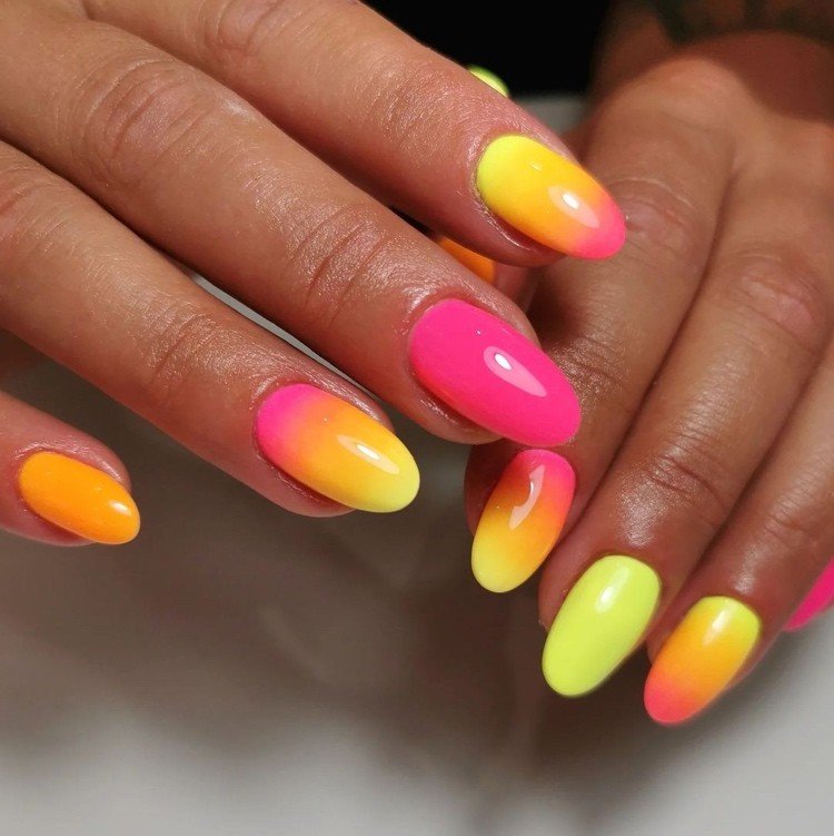 unhas neon com um gradiente entre laranja rosa e amarelo