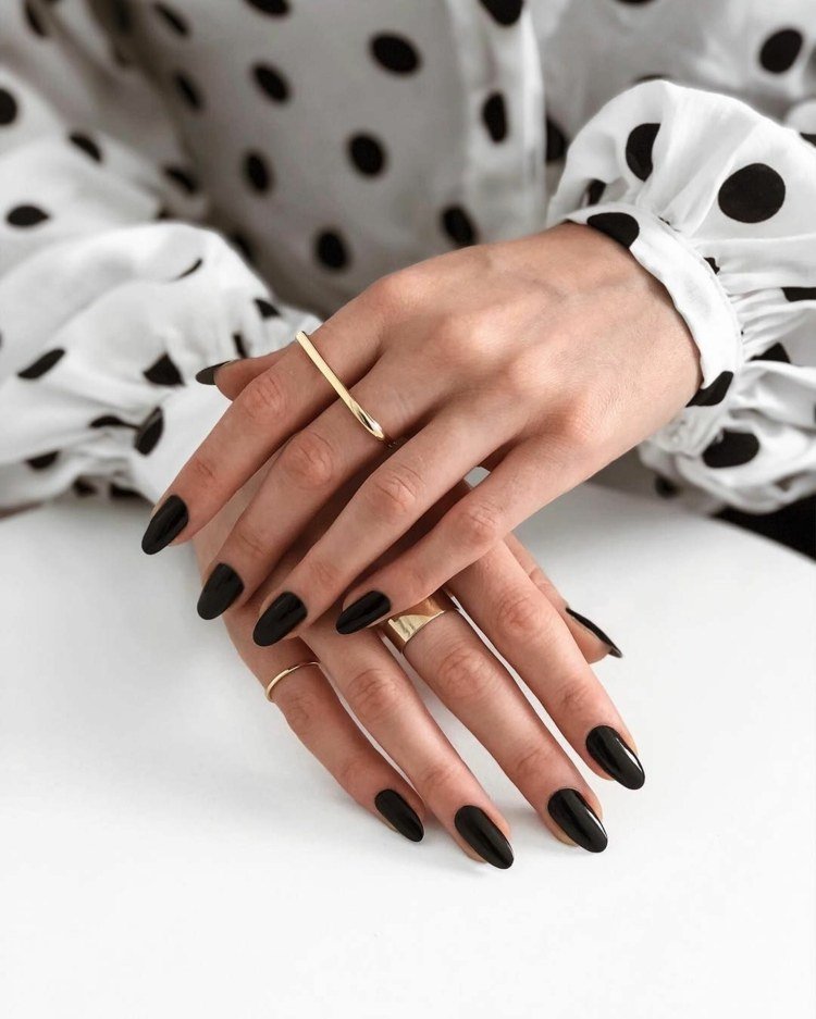 Unhas em formato de amêndoa tendências da moda esmalte preto anel dourado