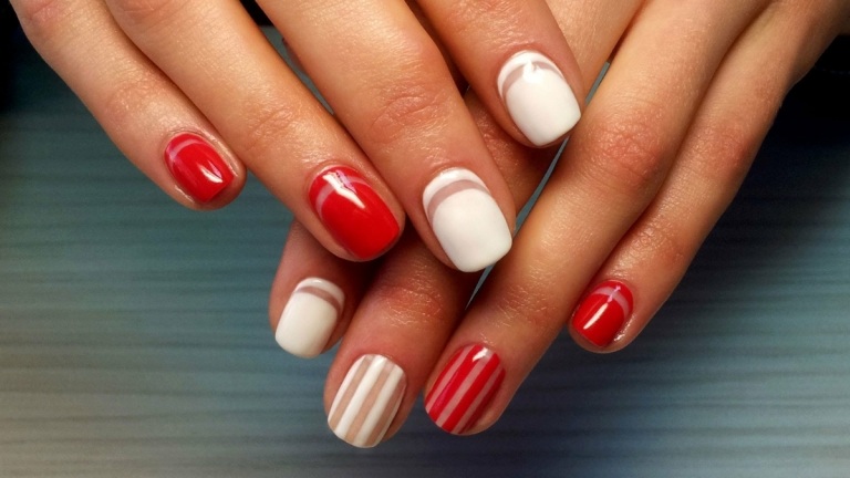 Design atraente de unhas de verão em vermelho e branco com listras nude