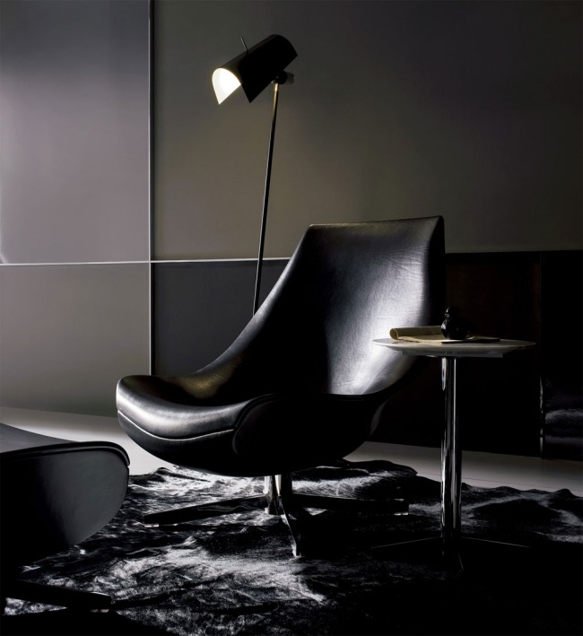 Poltrona relaxante, estofamento de couro, assento de formato moderno, apoios de braços, luminária de chão