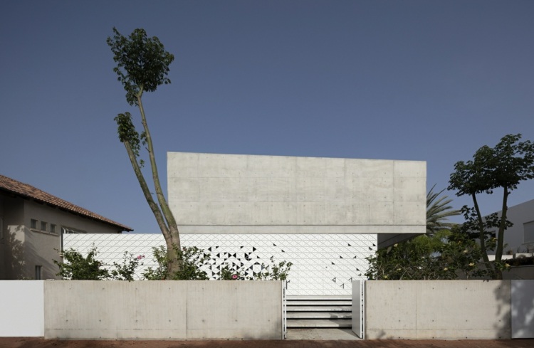 d3 house pitsou kedem architects fachada perfurada feita de triângulos perfurados de alumínio concreto exposto diagonalmente