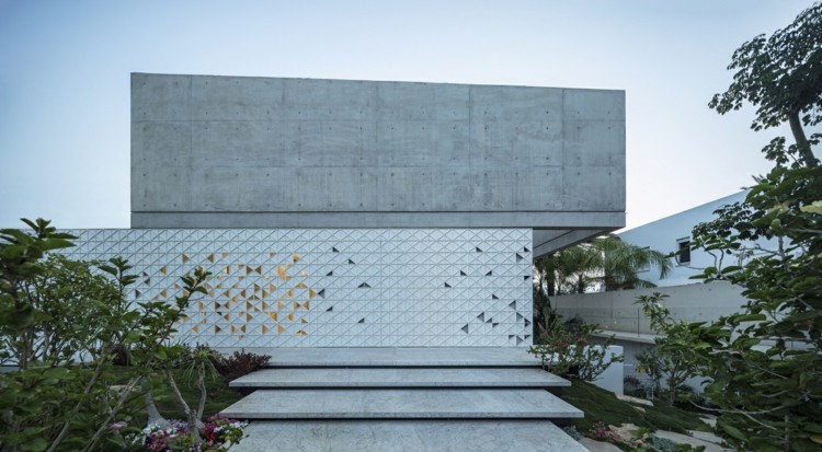 fachada de casa perfurada feita de triângulos brancos de alumínio padrão escadas de concreto exposto jardim de concreto esverdeado