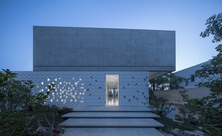 fachada perfurada padrão geométrico de alumínio branco triângulos sombras claras concreto exposto em um ângulo