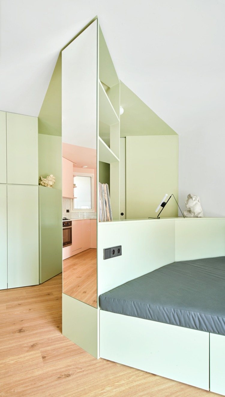 espelho instalado em uma coluna de suporte ao lado de um sofá-cama dobrável em uma pequena sala de estar
