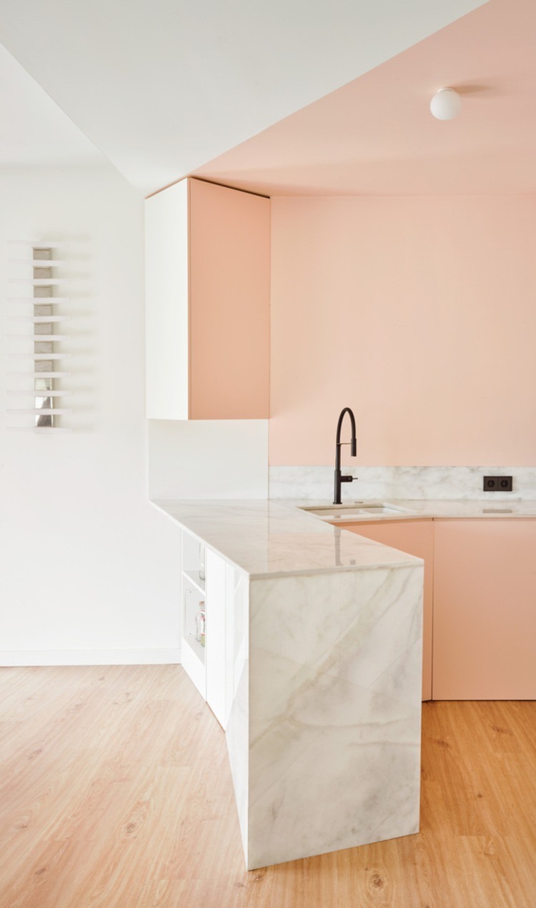 torneira contrastante em preto e bancada de cozinha em mármore branco sob paredes rosa claro