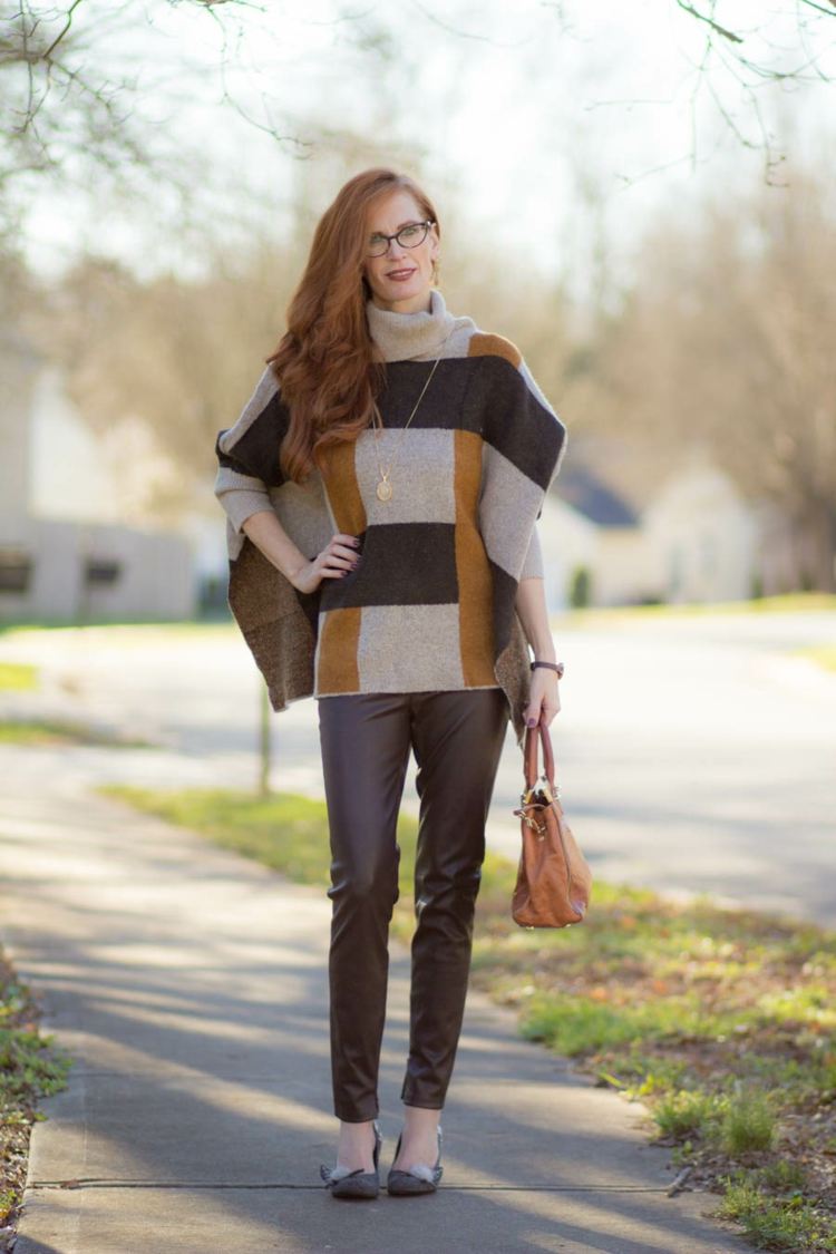 calça de couro marrom e poncho em cores semelhantes