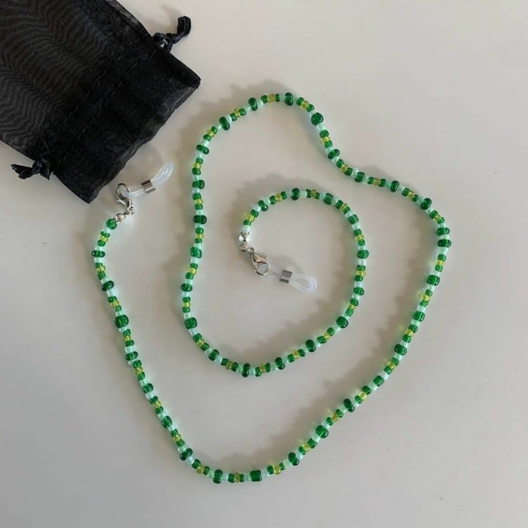 Máscara e corrente de óculos em um feito de pérolas verdes