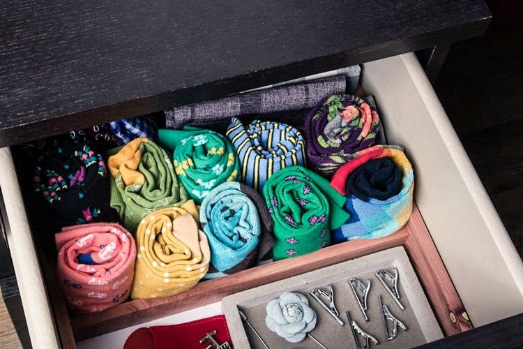 Segure o porta-meia com meias coloridas enroladas em uma gaveta