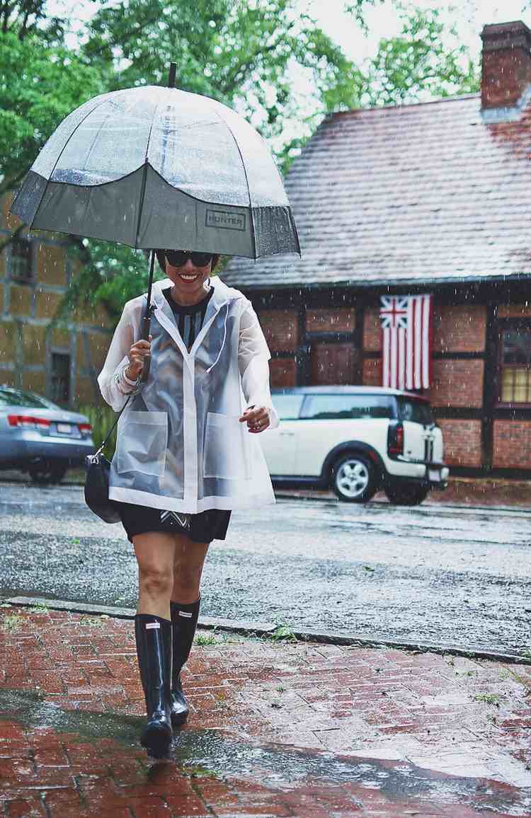 Combine roupa de verão quando chover botas de borracha com capa de chuva das tendências