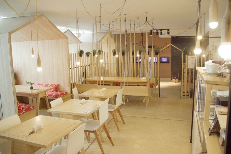 restaurante com mesas de balanço cordas lâmpadas cerca tiras de madeira