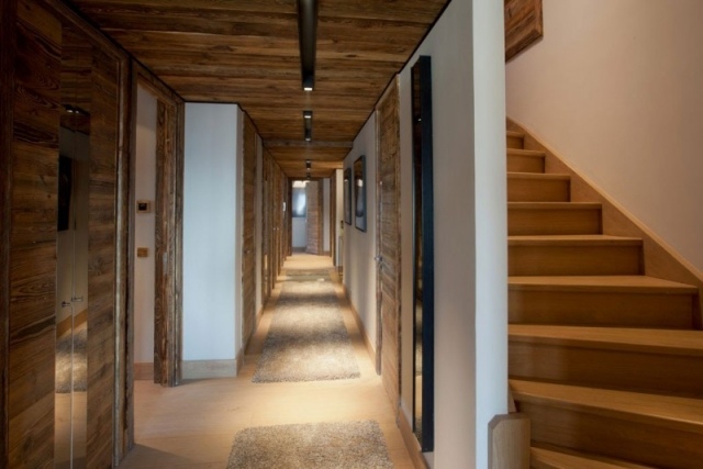 Luxuoso apartamento com vigas no teto em escada de corredor de estilo rústico