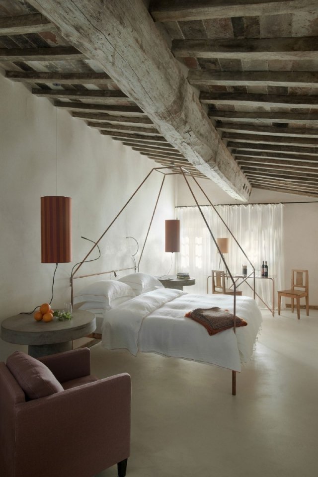 Quarto de hotel rústico com cama de dossel no teto com viga de madeira
