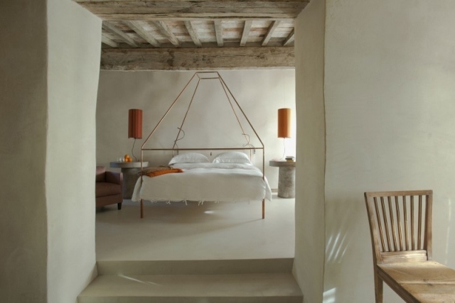 Parede de gesso rústico com cama de dossel Hotel Monteverdi com estrutura de metal