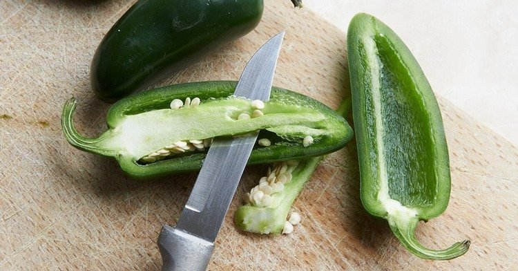 Divida os jalapenos pela metade e retire o núcleo para desarmar