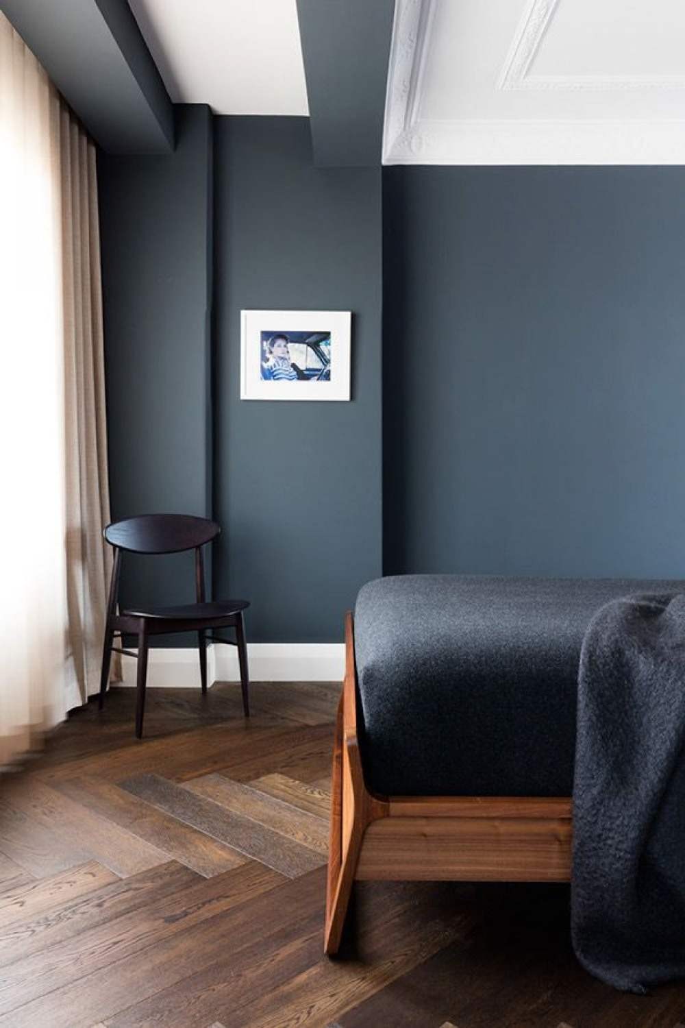quarto com piso escuro feito de tábuas de madeira em combinação com a cor escura da parede