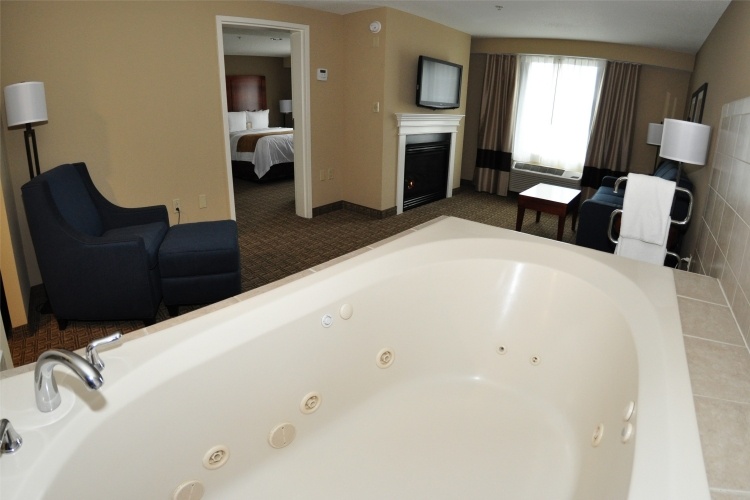 quarto-whirlpool-tub-white-open-bathroom-bed-television-window
